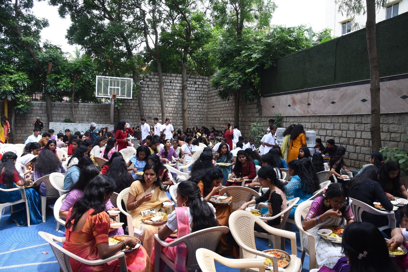 Students gathered outdoors on the AECS campus sports court