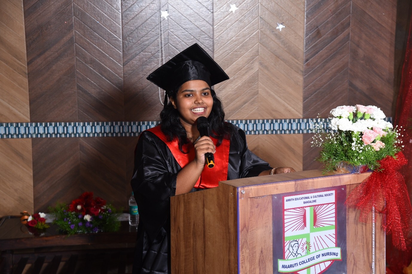 AECS nursing graduate speaking at the podium during an academic ceremony