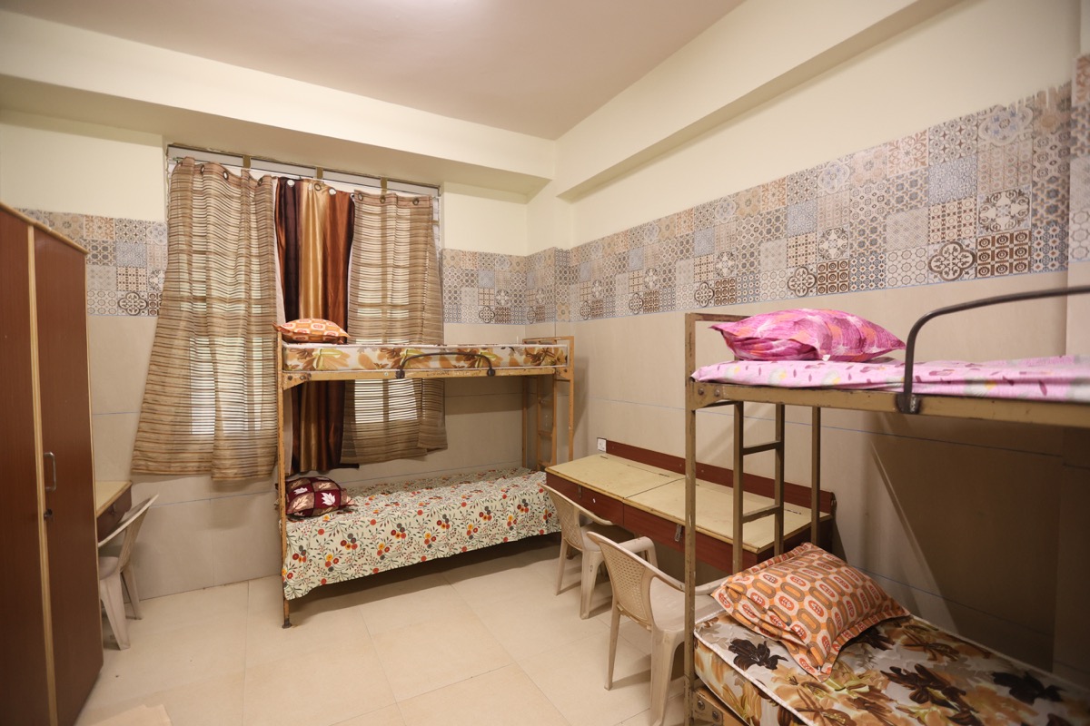 AECS Maaruti College of Nursing hostel room with bunk beds, wardrobes, and study space