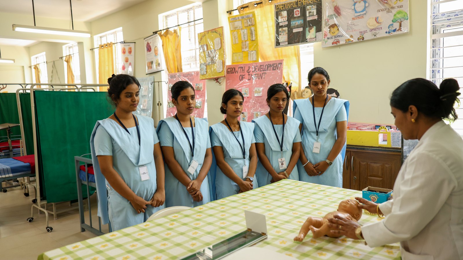 Faculty demonstrating neonatal care skills to nursing students