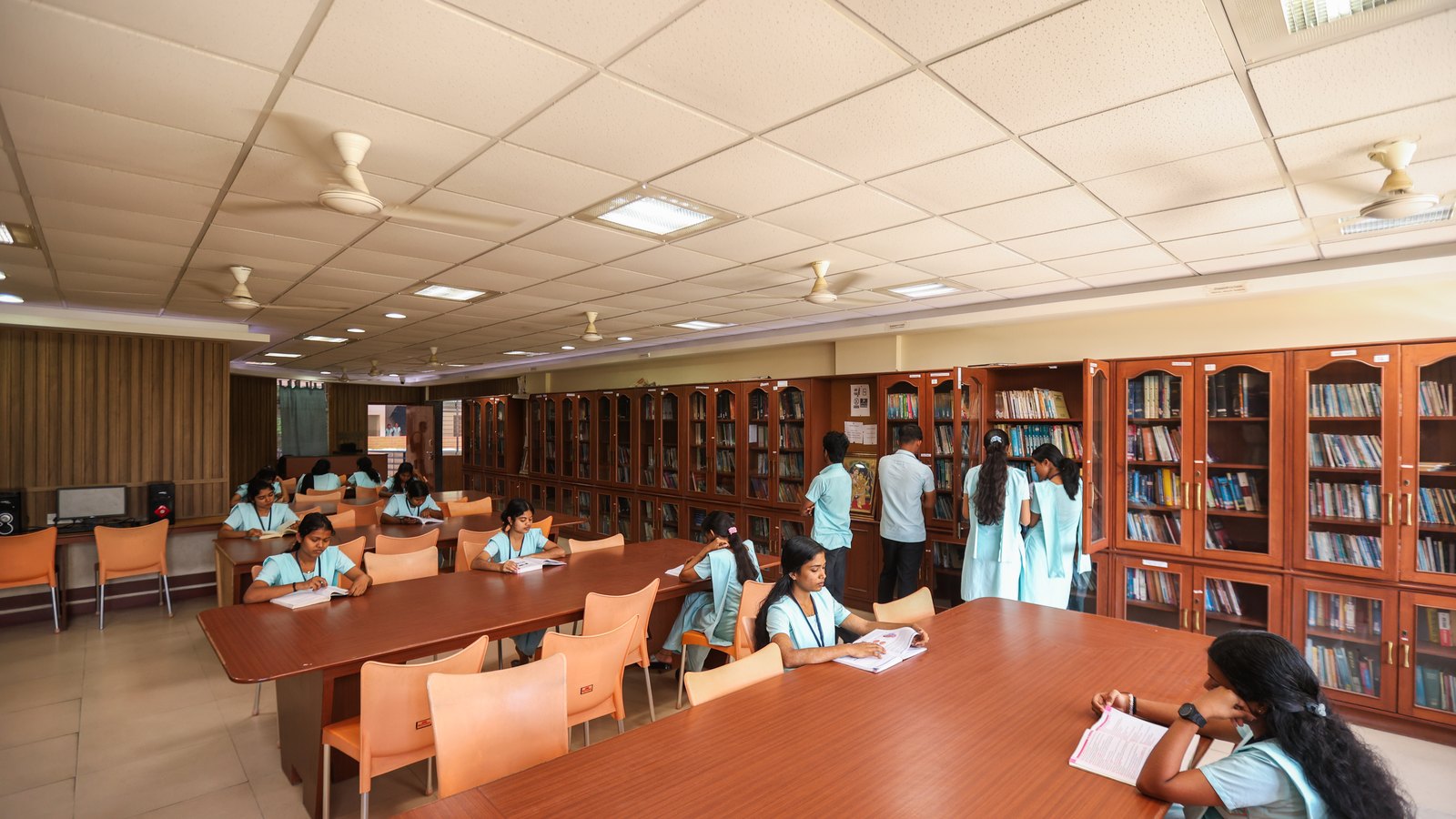 Library study area with students reading and using reference shelves